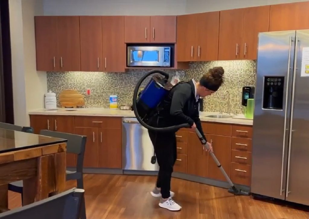 woman vacuuming office kitchen